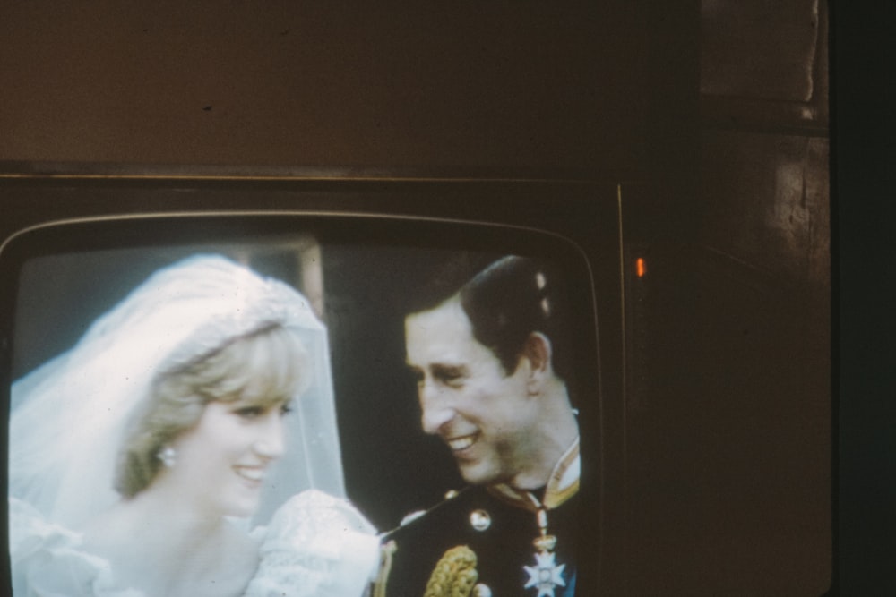 man in black and white suit beside woman in white dress