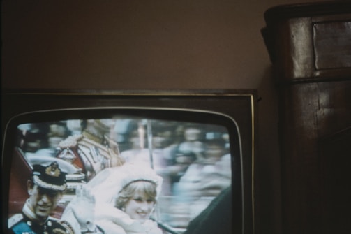 Wide shot of a government event with videotron displaying official logos.