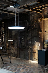 black pendant lamp turned on near brown wooden wall