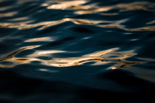 Soft glowing gold light waves over a deep navy backdrop, evoking calm and balance.