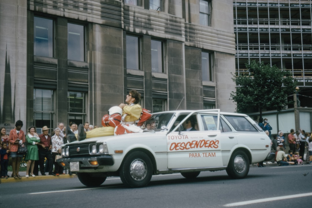 people riding white and red car on road during daytime