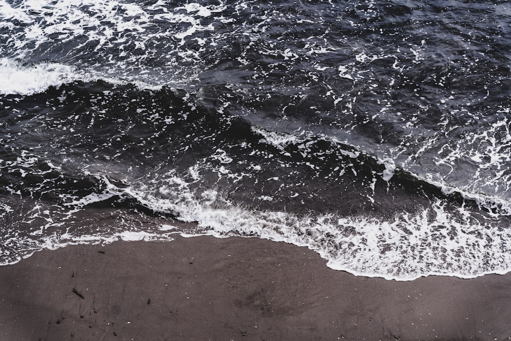 sea waves on brown sand during daytime