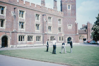 man and woman walking on sidewalk near brown concrete building during daytime