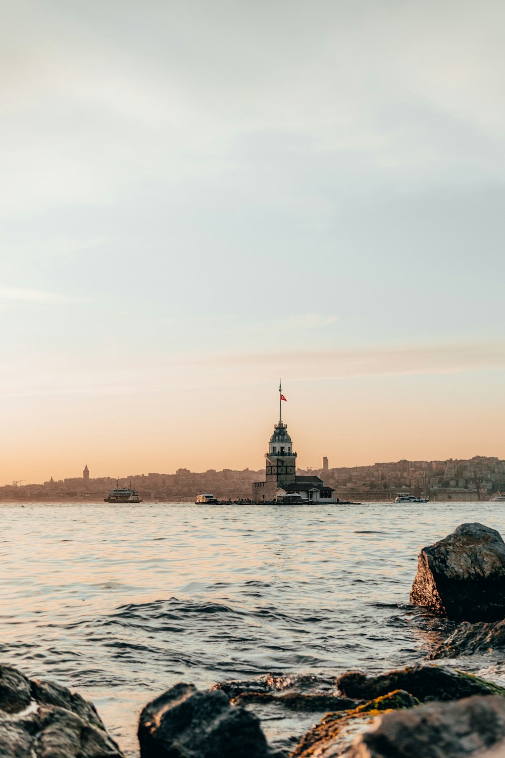 black and brown tower on the sea shore during sunset