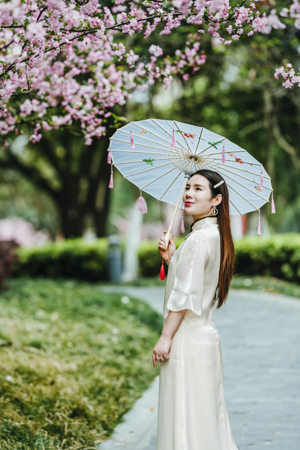 woman in white dress holding umbrella