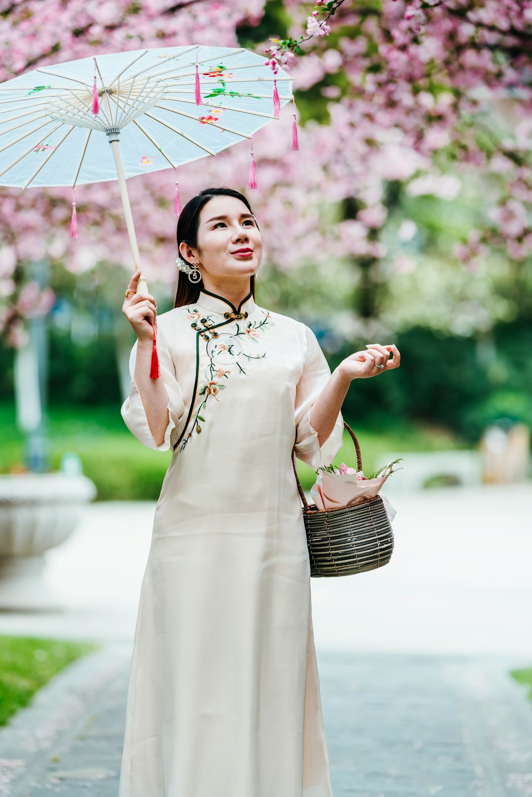 woman in white and pink floral dress holding umbrella