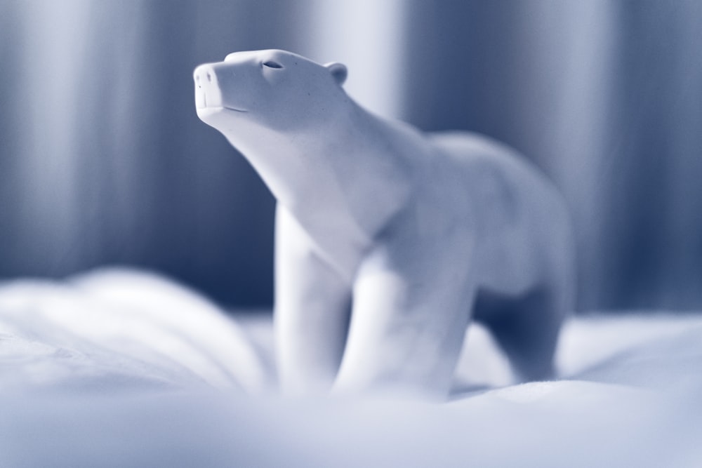white polar bear figurine on white textile