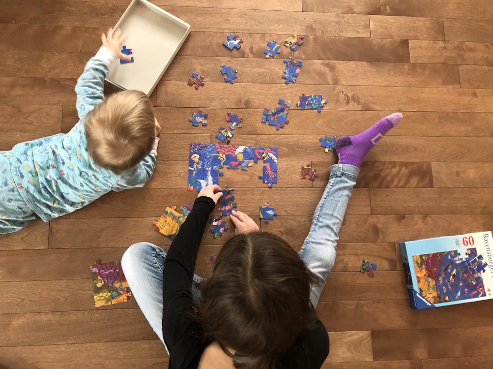 girl in teal long sleeve shirt playing with girl in teal shirt