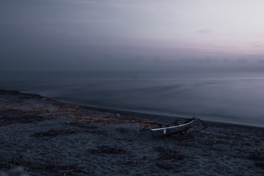 white boat on seashore during daytime in Zambales Philippines