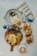 A breakfast or brunch spread on a marble table with two cups of latte art coffee, a plate with an egg and salad, croissants filled with salad and eggs, and a wooden serving board with scrambled eggs, bread, sausages, a hash brown, and some greens.
