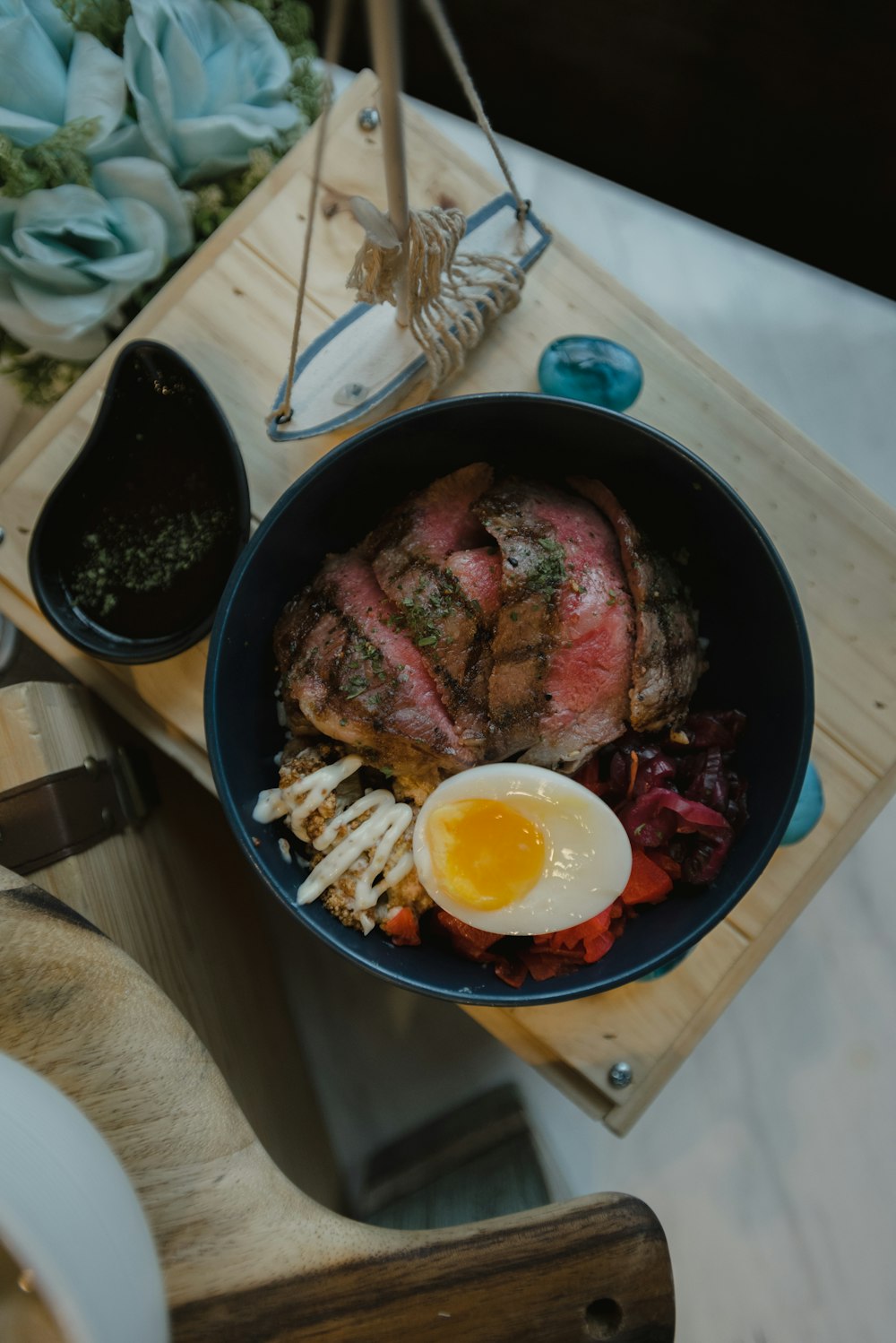 cooked meat with egg on black ceramic bowl
