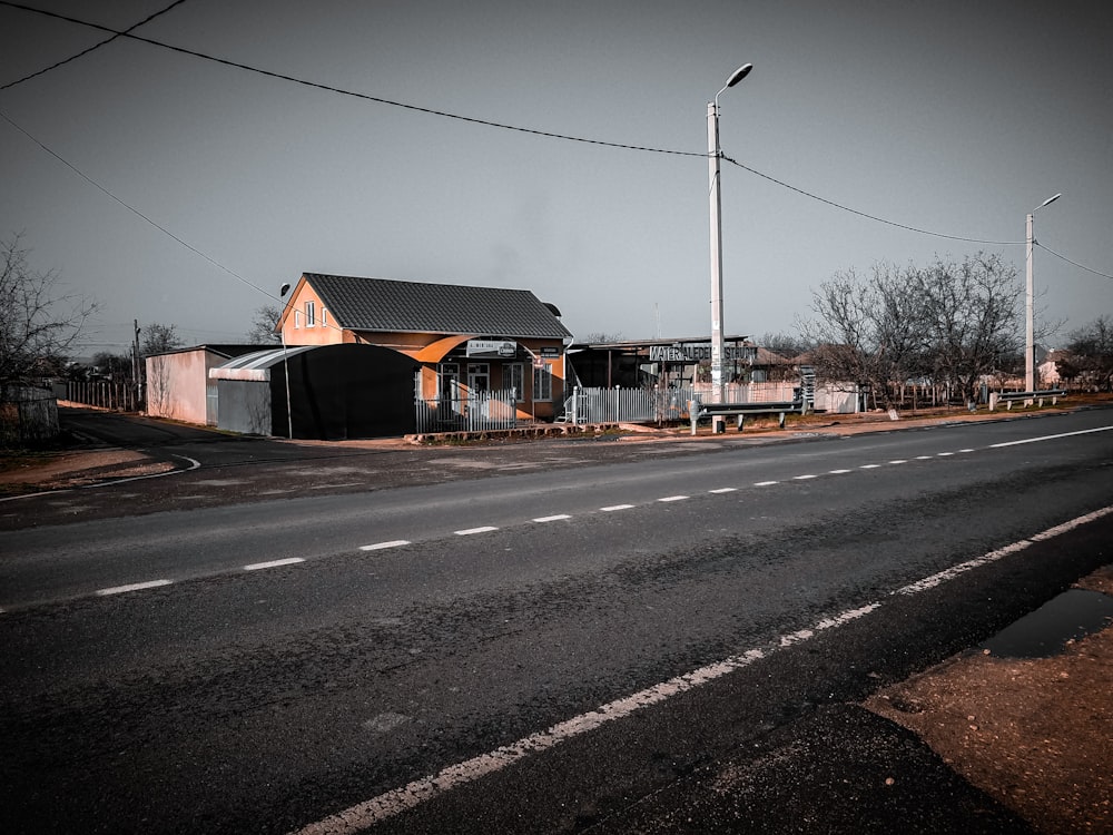 brown wooden house beside road during daytime