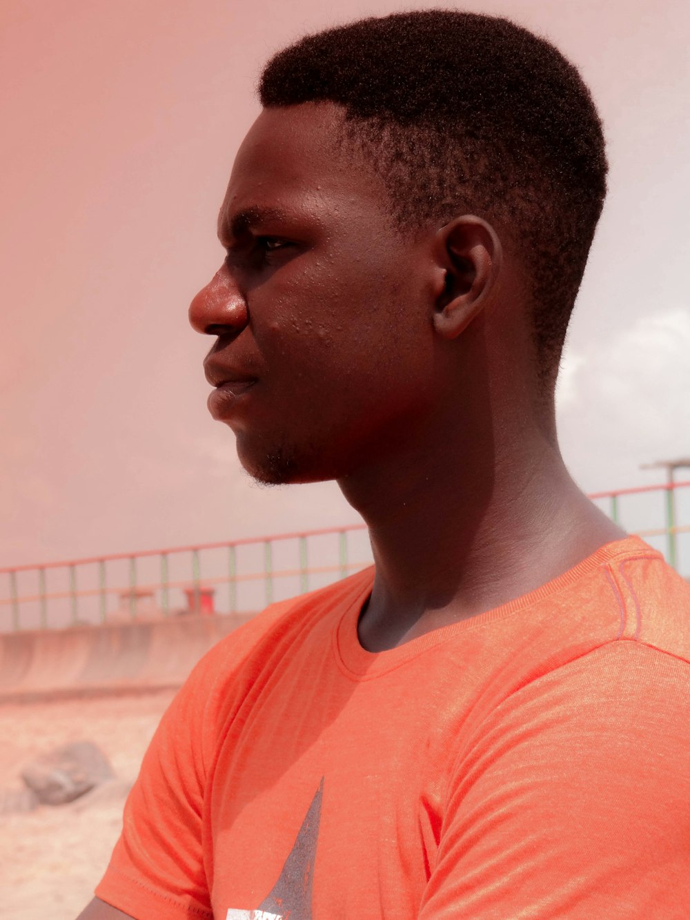 a man in an orange shirt is holding a cell phone