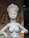 Close-up of a smiling woman holding a detailed custom sculpture in a cozy home setting