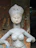 Close-up of a smiling woman holding a detailed custom sculpture in a cozy home setting