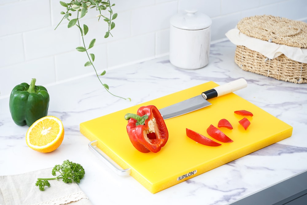 red bell pepper on yellow chopping board
