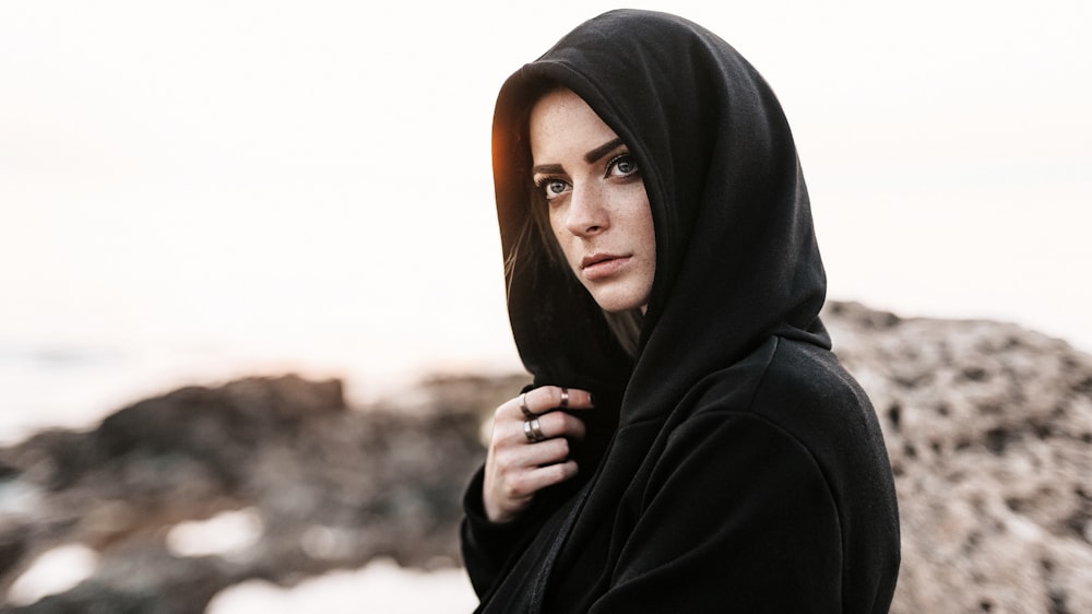 woman in black hijab covering her face with her hand