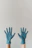 Close-up of hands wearing snug surgical gloves against a soft blue background.