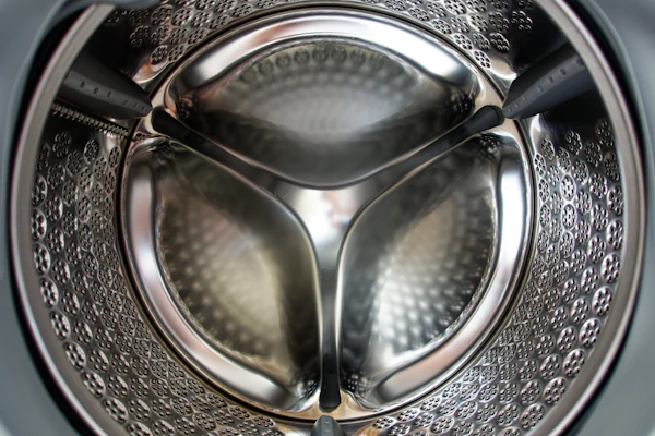 Technician diagnosing drum noise and vibration on a washing machine