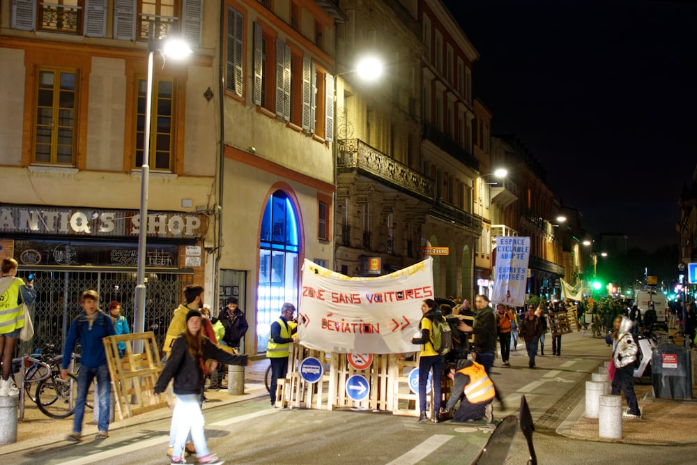 people walking on street near brown concrete building during nighttime