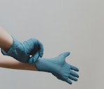 person in blue gloves and blue denim jeans