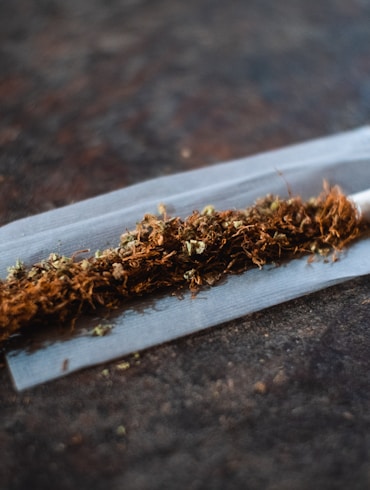 white cigarette stick on brown wooden table