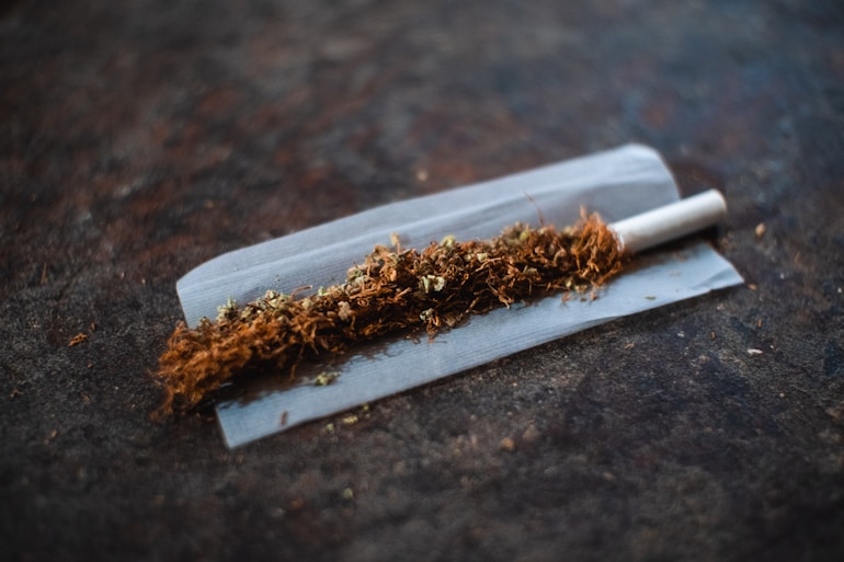 white cigarette stick on brown wooden table