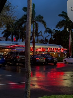 Cozy roadside diner with a neon sign glowing warmly at dusk.