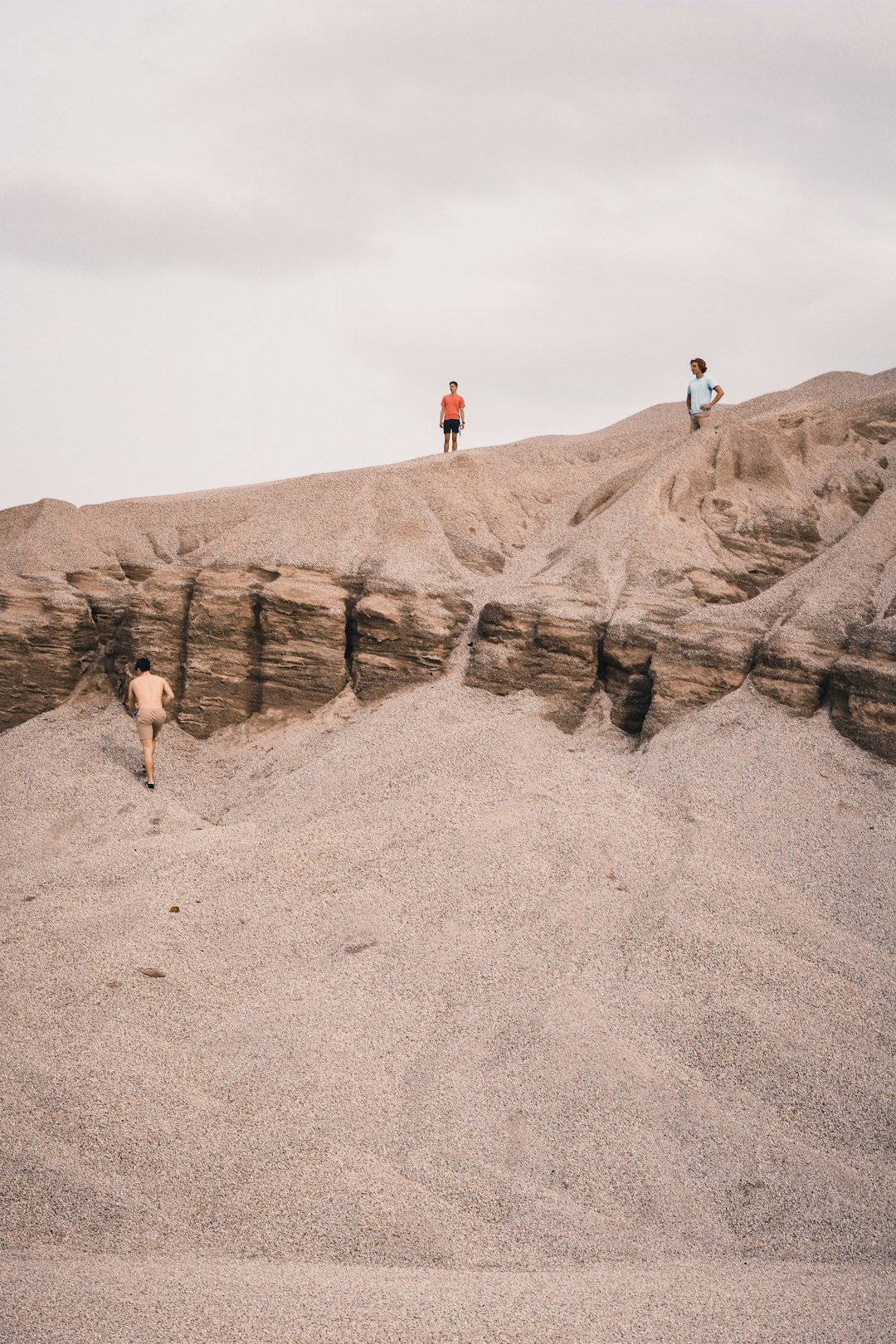 2 person walking on brown rocky mountain during daytime