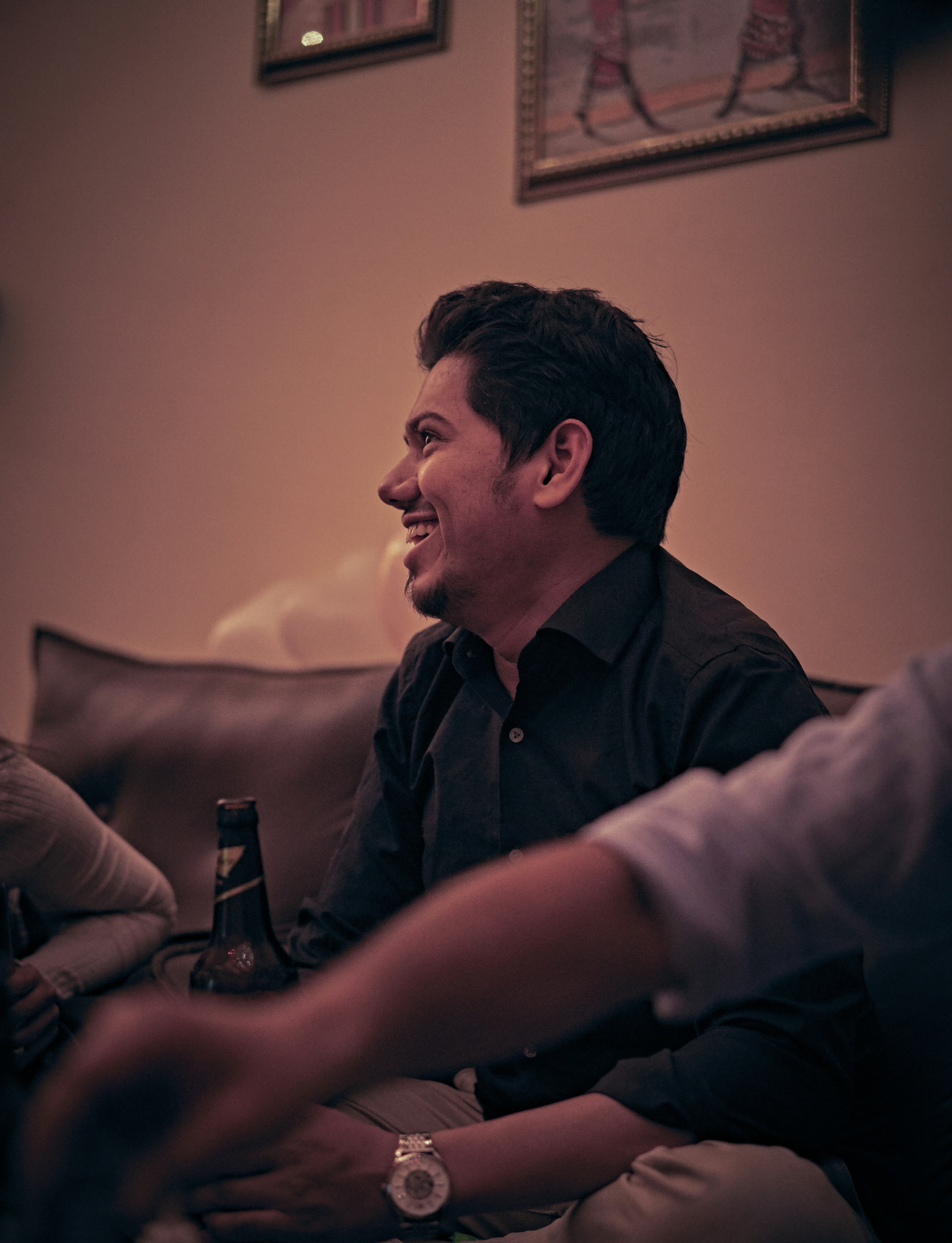 man in black button up shirt holding bottle