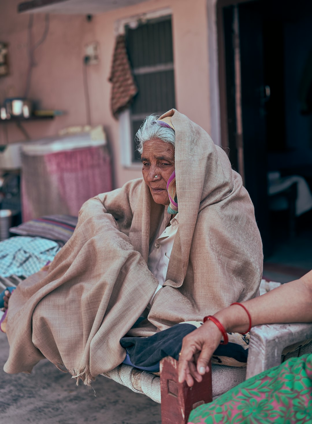 woman in brown robe sitting on red and white textile