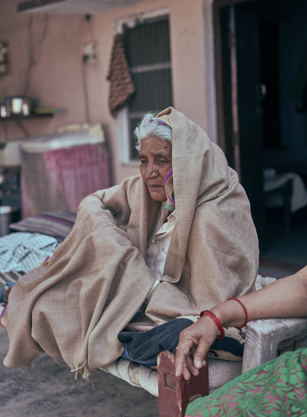 woman in brown robe sitting on red and white textile