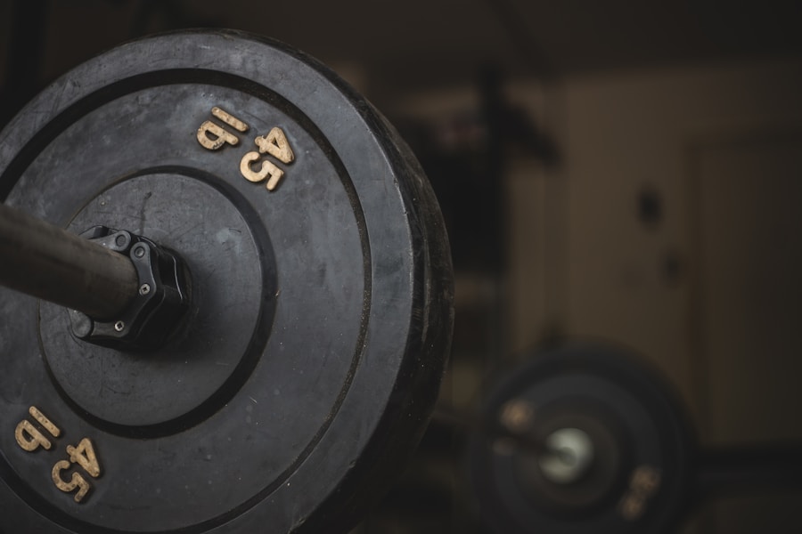 Worn bumper plates loaded on a bar in a garage-style gym