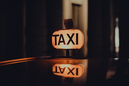 Close-up of a taxi's dome light glowing with 'Taxi Verdun' logo at night