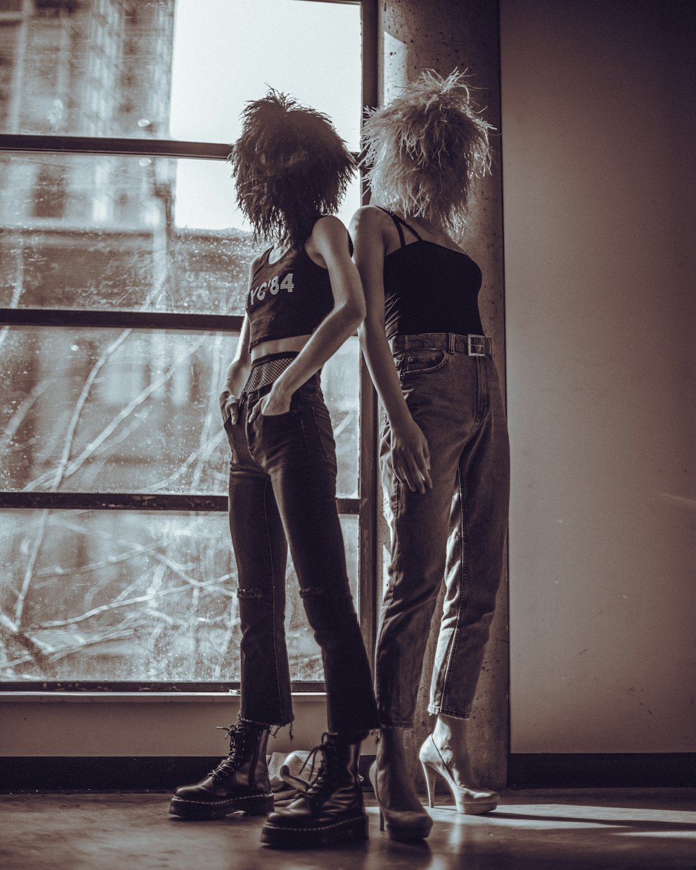 woman in gray tank top and gray pants standing beside window