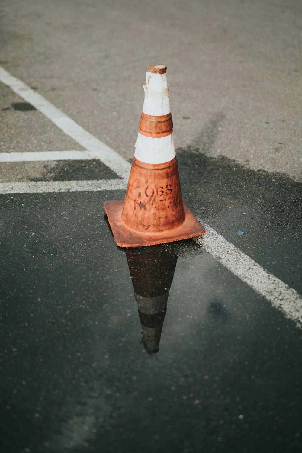 cone de tráfego laranja e branco na estrada de asfalto preto
