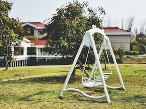 white metal swing chair on green grass field