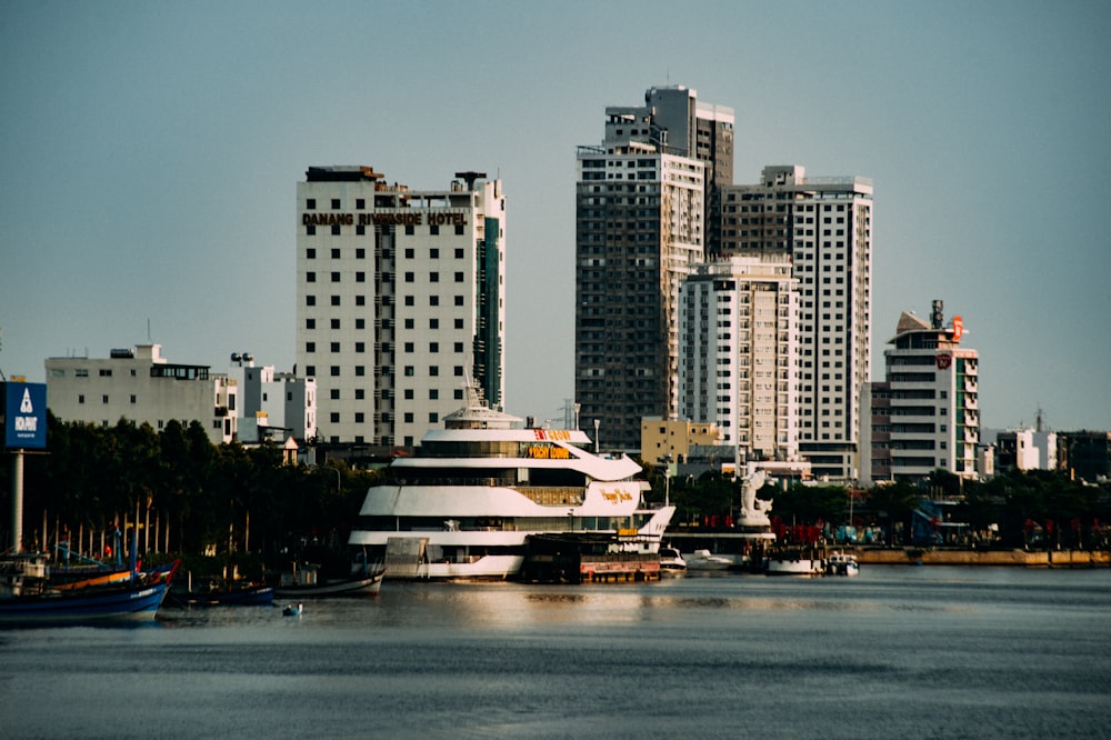 white and brown ship on water near city buildings during daytime