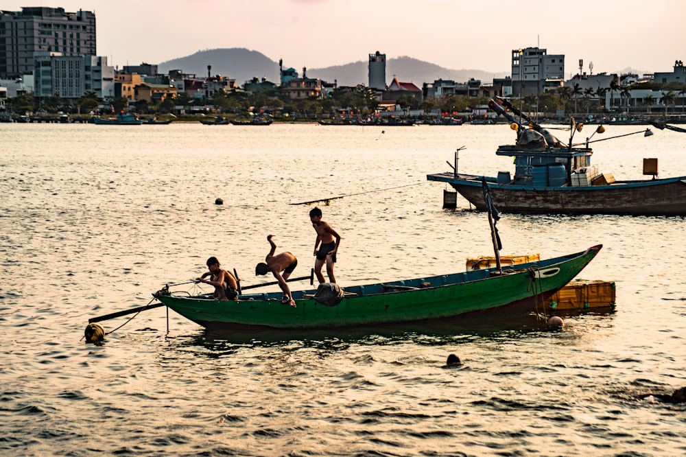 2 men and woman sitting on green and brown boat on beach during daytime