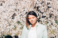 woman in white dress shirt standing near white flowers