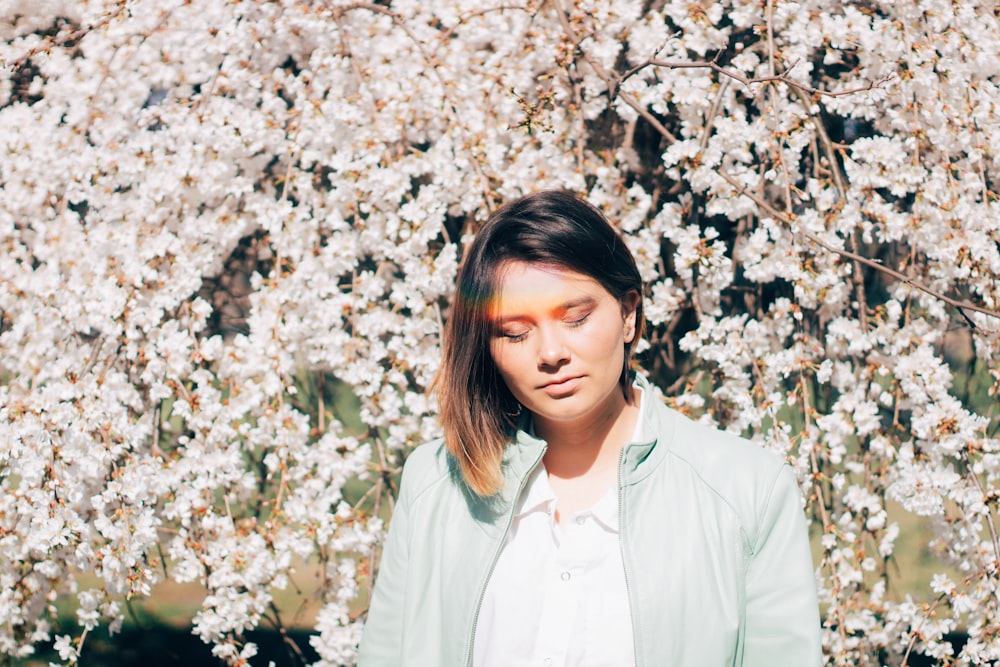 woman in white dress shirt standing near white flowers