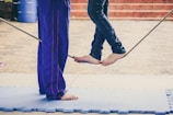 Young students balancing on a colorful tightrope under the guidance of an instructor.