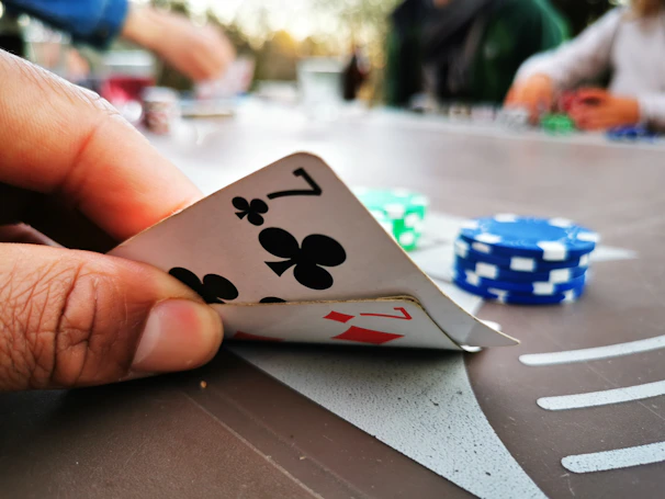 Close-up of a winning hand of cards being held over a green felt poker table