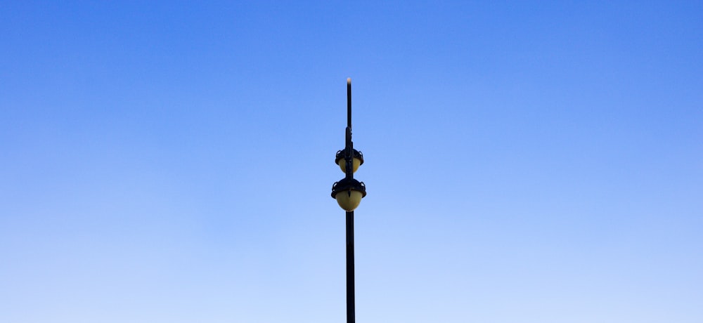 Farola blanca y negra bajo cielo azul durante el día