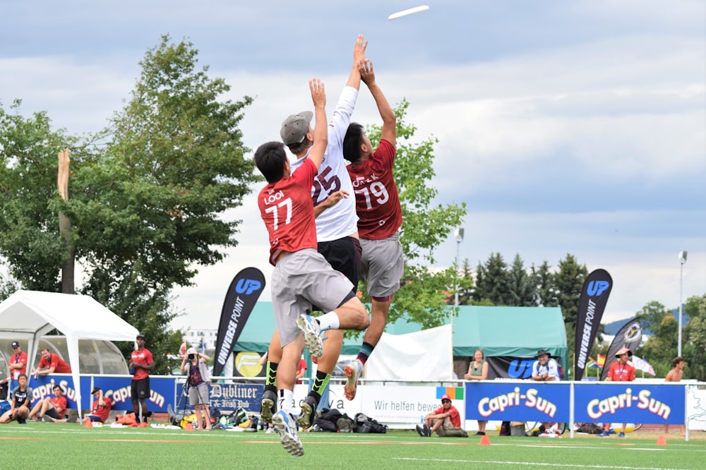 man in red and white jersey shirt playing soccer during daytime