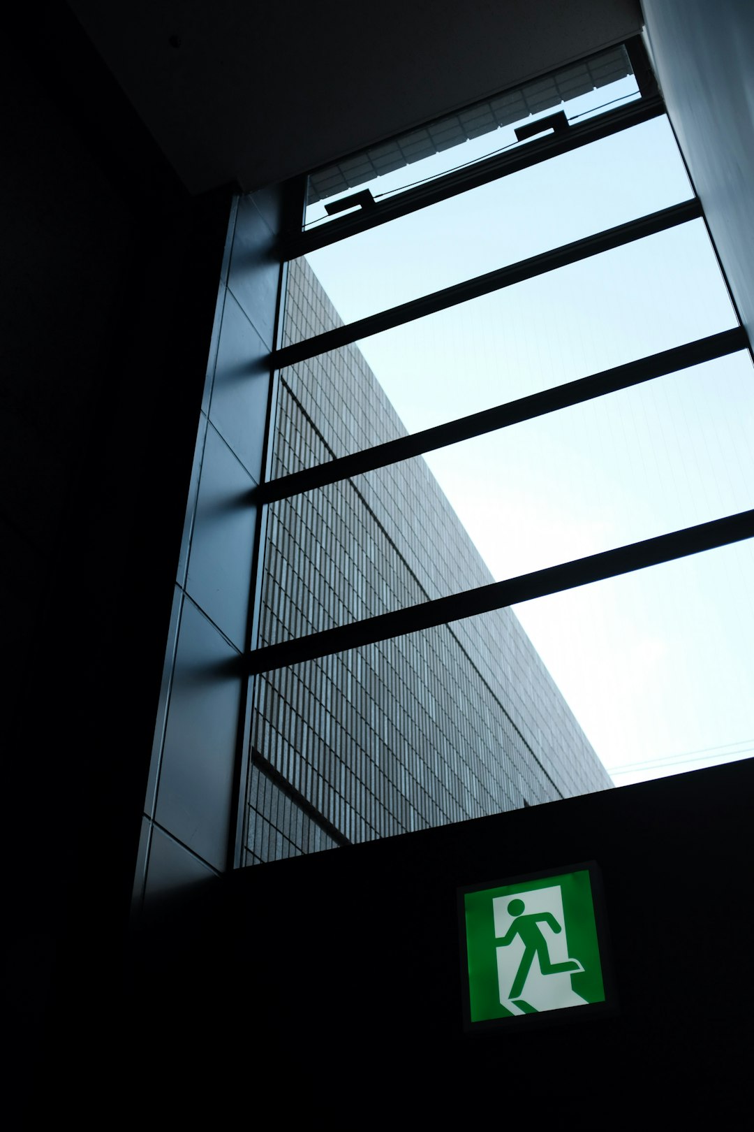 green and white sign on gray wall