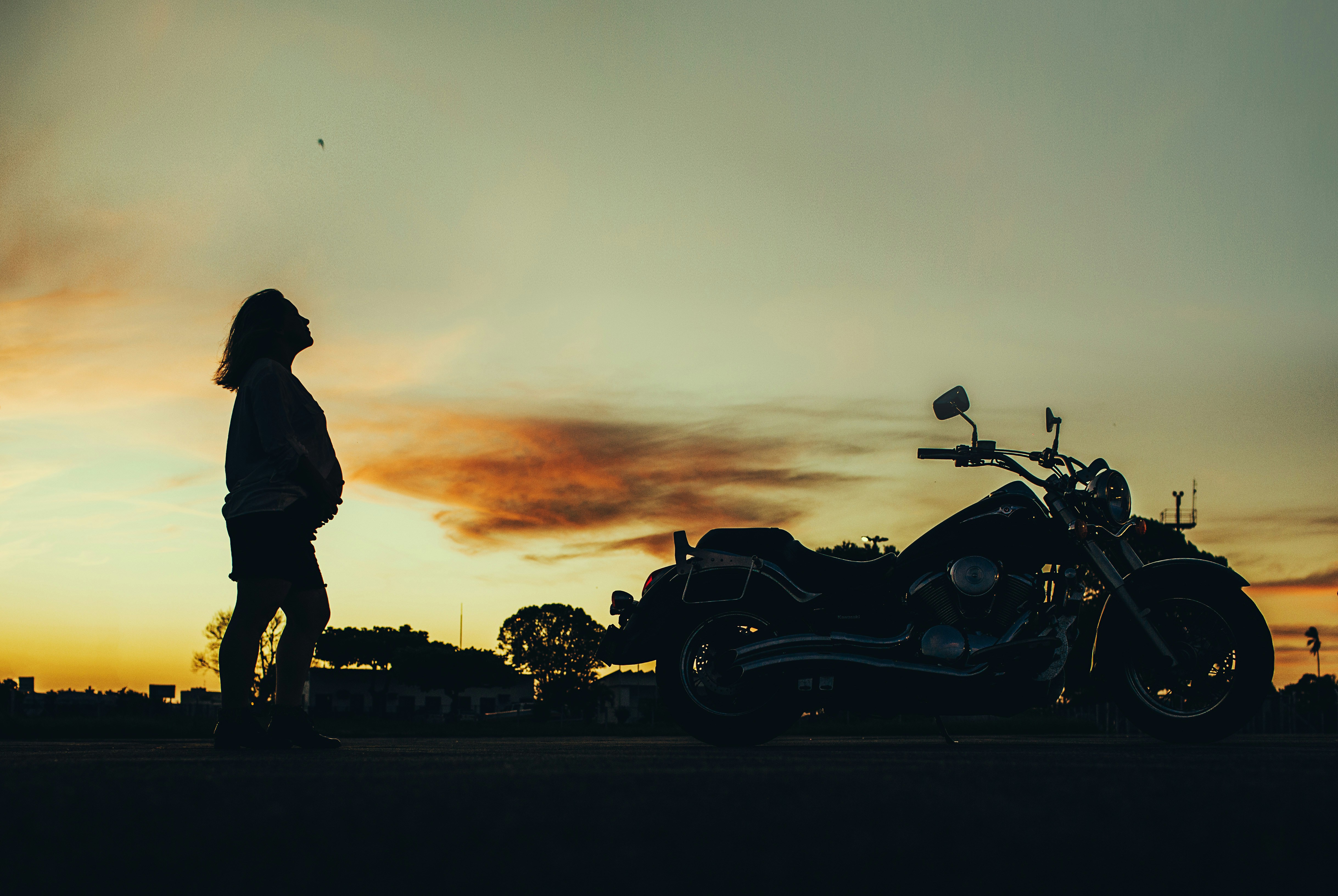 silhouette of man riding motorcycle during sunset