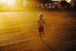 Child playing in golden sunlight with joyful expression