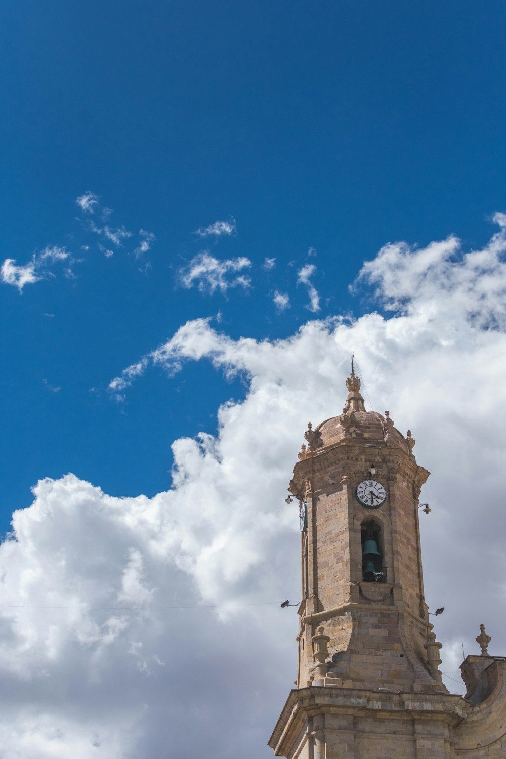 brown concrete building under blue sky and white clouds during daytime