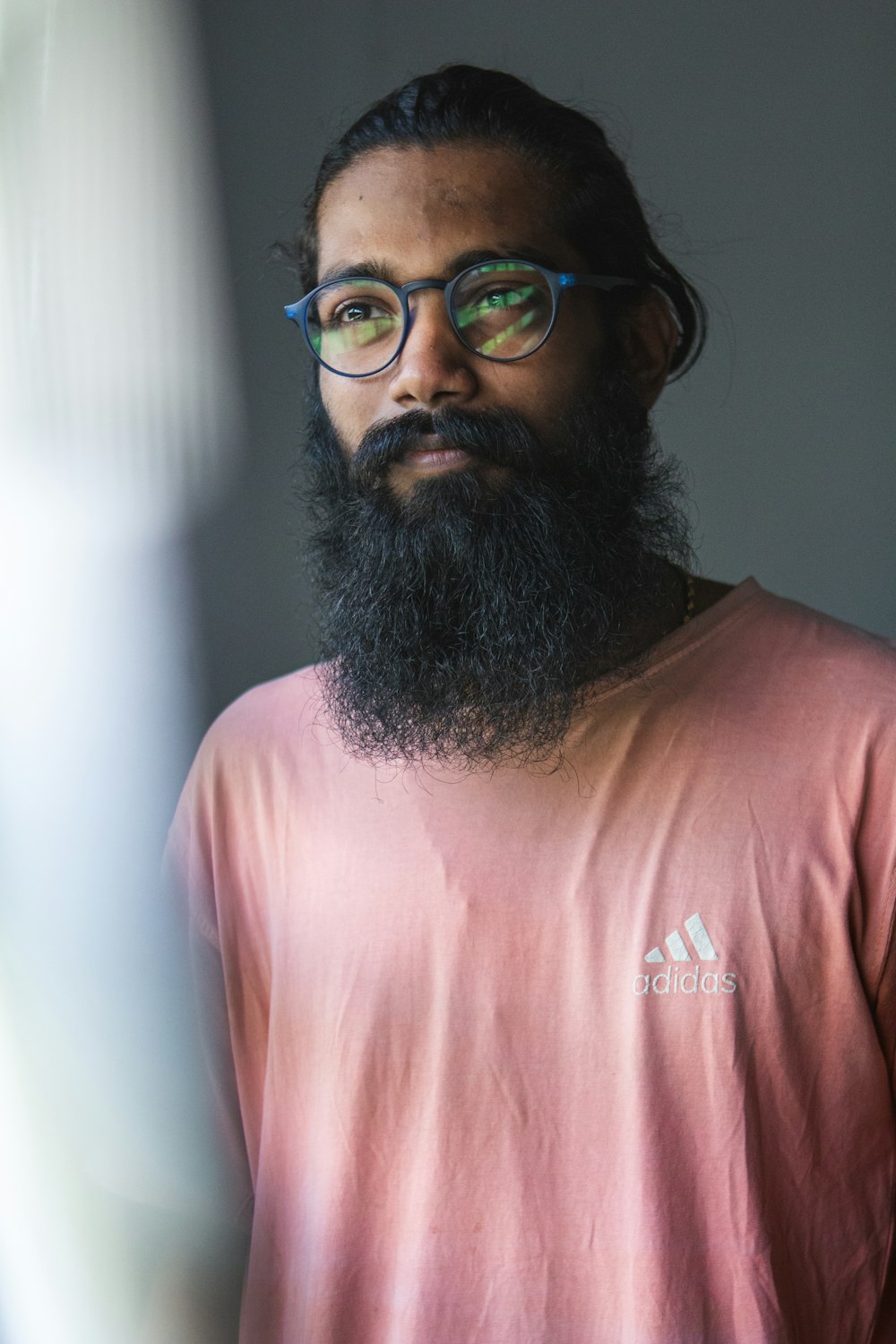 man in pink crew neck t-shirt wearing black framed eyeglasses